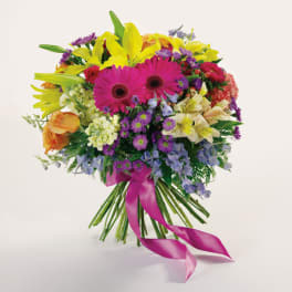 Bright mixed bouquet with pink gerberas, yellow lilies, and a pink ribbon