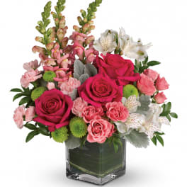 Pink roses and alstroemeria in a square glass vase