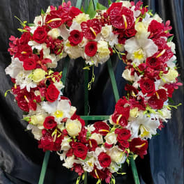 Heart-shaped floral wreath with red and white roses and orchids