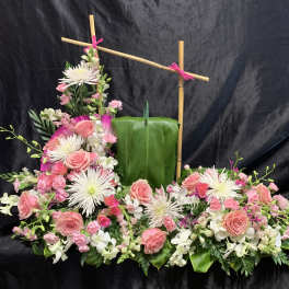 Pink roses and white spider mums arranged around a green leaf panel.