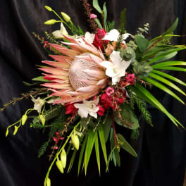 Large tropical bouquet with a protea, white lilies, and red blooms