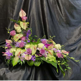 Pink and lavender floral arrangement with anthuriums and roses