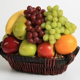 Fruit basket with grapes, bananas, apples, pears, and an orange