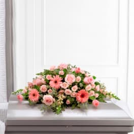 Pink rose and gerbera daisy casket spray on a white casket
