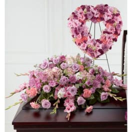 Pink and lavender funeral casket spray with matching heart-shaped standing wreath.