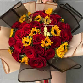 Bouquet of red roses and yellow sunflowers wrapped in tan and black paper