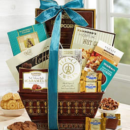 Gourmet gift basket filled with assorted cookies, caramels, nuts, and snacks with a teal bow
