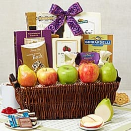 Gift basket of apples, pears, and assorted gourmet snacks topped with a purple bow