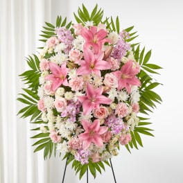 Pink and white floral standing spray on a black easel