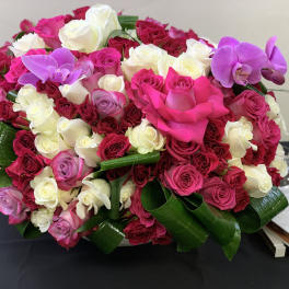 Large bouquet of pink, white, and purple roses with orchids