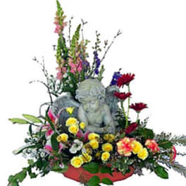 Floral arrangement with a cherub statue and mixed flowers in a low container