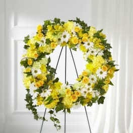 Yellow and white floral wreath on a black stand