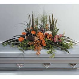 Orange floral spray on a silver casket