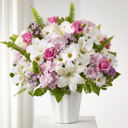 Pink roses and white lilies in a white vase