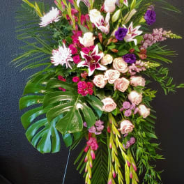 Standing floral spray with pink and white flowers on a black easel