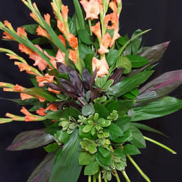 Tall tropical bouquet with peach gladiolus and mixed foliage