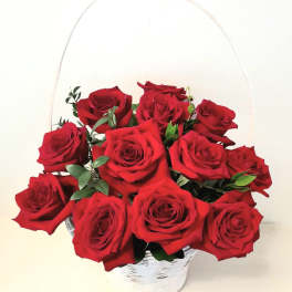 Basket of red roses with greenery