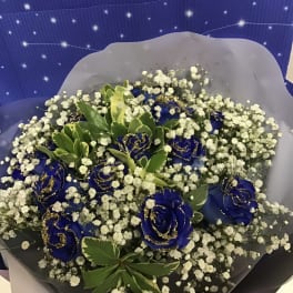 Bouquet of blue roses with white baby's breath and green foliage