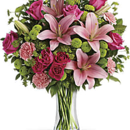 Pink lilies and roses in a clear glass vase