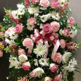 Standing floral spray with pink roses, carnations, and white daisies