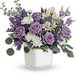 Lavender roses and white flowers in a white square vase