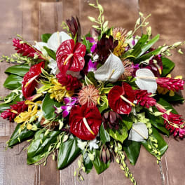 Tropical floral arrangement with red and white anthuriums and orchids