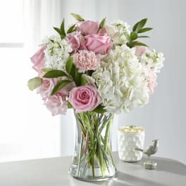 Pink roses and white hydrangeas in a clear glass vase