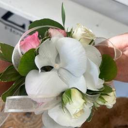 Small bouquet with white orchids and pink roses tied with sheer ribbon