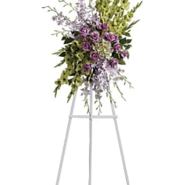 Purple and green floral standing spray on a metal easel