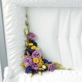 Purple and yellow floral arrangement on a white chair