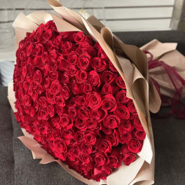 Large bouquet of red roses wrapped in beige paper