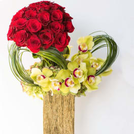 Red roses and yellow orchids in a gold vase