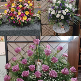 Three large floral arrangements with roses, daisies, and mixed blooms in a church setting.