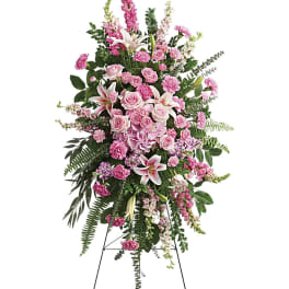 Tall pink and white standing spray of roses, lilies, and carnations on a metal easel