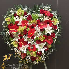 Heart-shaped floral spray with red, white, and green flowers on an easel