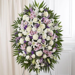 Large standing floral spray with white and lavender flowers on a stand