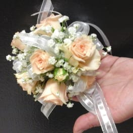 Small peach rose corsage with white ribbon and baby's breath