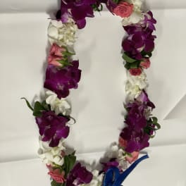 Flower lei with purple orchids, white blooms, pink roses, and a blue ribbon