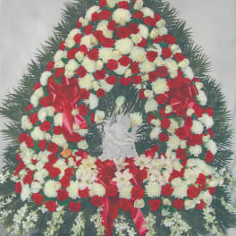 Large funeral wreath of red and white flowers with red ribbons