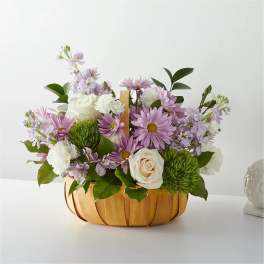 Lavender and white flower arrangement in a wooden basket