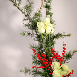 White roses with red berries in a black vase