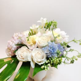 White roses and pastel flowers in a white vase