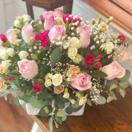 Pink and white rose bouquet in a white container