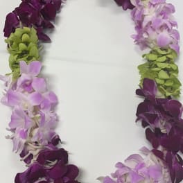 Purple, lavender, and green orchid lei on a white surface