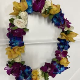 Colorful floral wreath with orchids and roses on a white surface