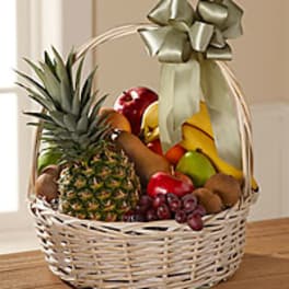 Fruit basket with pineapple, bananas, apples, grapes, and kiwi