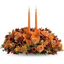 Autumn floral centerpiece with two orange taper candles