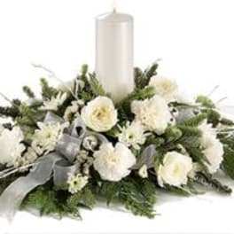 White floral candle centerpiece with a tall pillar candle