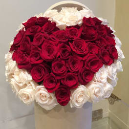Heart-shaped bouquet of red and white roses in a white box