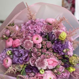 Pink and purple mixed bouquet with roses and ranunculus in pink wrap
